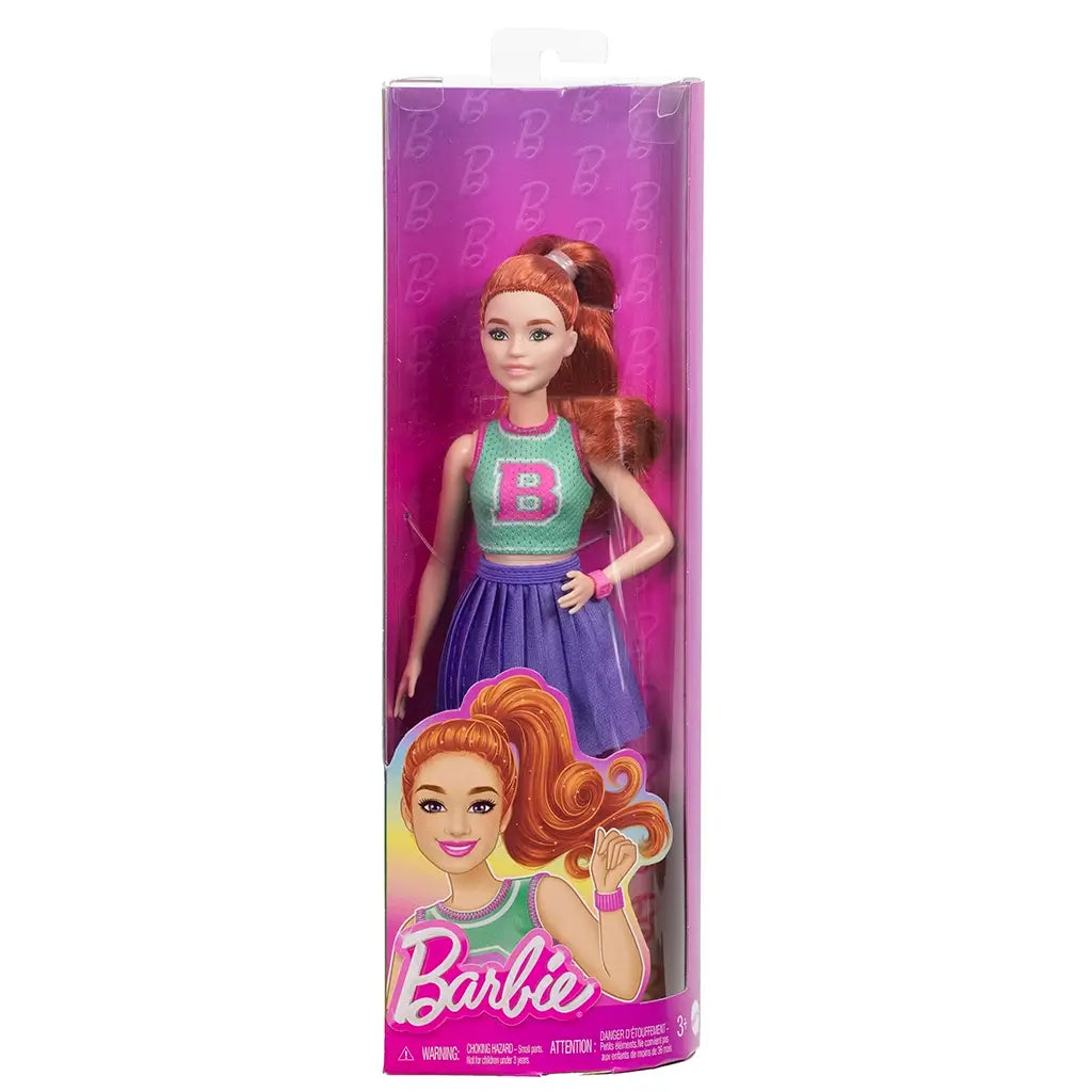 Barbie Fashionistas 232 doll in retail package with clear front, featuring artwork of doll in teal B top, purple skirt, and pink accessories on pink background.