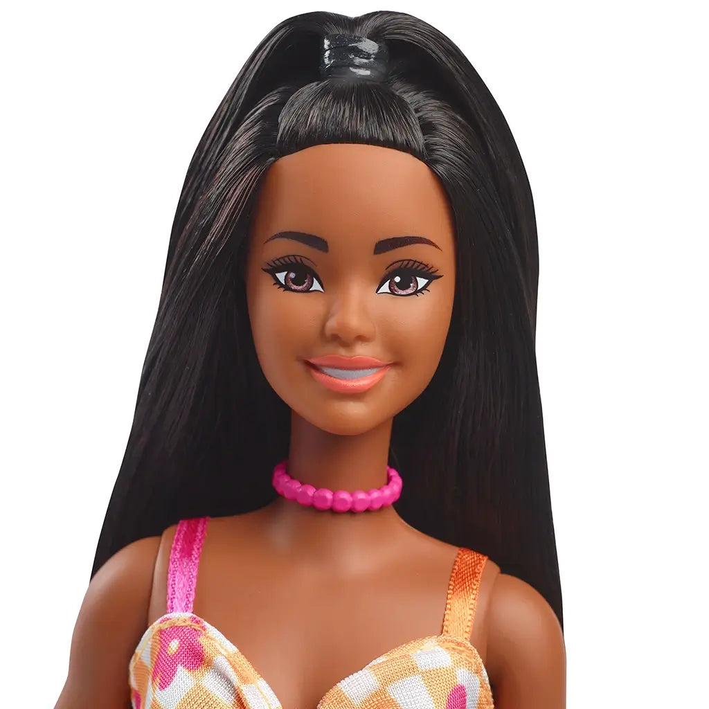 Close-up of Barbie Fashionistas 233 doll’s face with long black hair, pink lipstick, and a bright pink bead necklace.