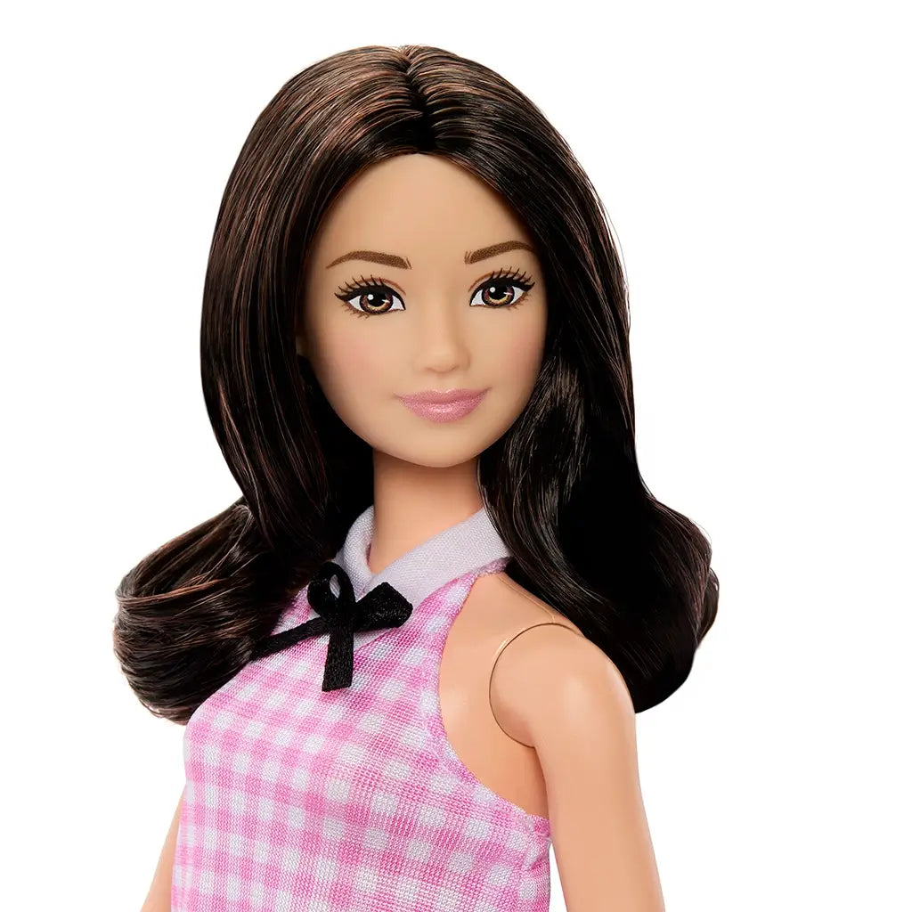 Close-up portrait of Barbie Fashionistas doll 224 with long wavy black hair, brown eyes, and pink lipstick, wearing a pink gingham dress with black bow detail.