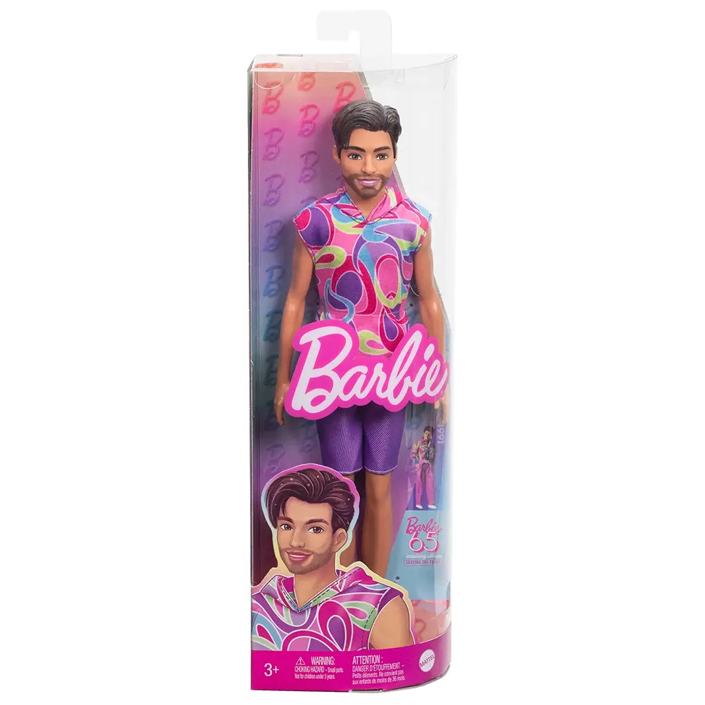 Barbie Fashionistas Ken doll #227 in packaging, featuring brunette hair, beard, colorful sleeveless hoodie with swirl patterns, purple shorts, and white sneakers.