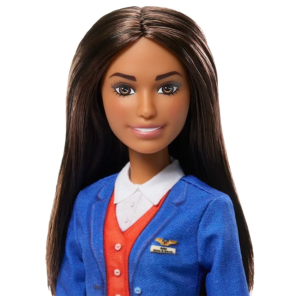 Close-up of Barbie flight attendant doll’s face with long brunette hair, wearing a blue jacket with airline badge, red vest, and white collared shirt.