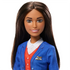 Close-up of Barbie flight attendant doll’s face with long brunette hair, wearing a blue jacket with airline badge, red vest, and white collared shirt.