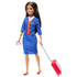 Barbie flight attendant doll in blue uniform with red vest and white shirt, pulling a red rolling suitcase and holding a pink passport accessory.