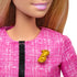 Detailed close-up of Barbie Future Leader doll’s textured pink jacket with gold B brooch and black zipper accent, highlighting her professional campaign-inspired fashion outfit.