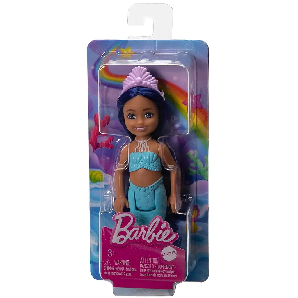 Barbie Chelsea mermaid doll packaged on a colorful ocean-themed card with rainbow, coral, and seashell graphics, featuring her in aqua top and blue-to-purple mermaid tail.