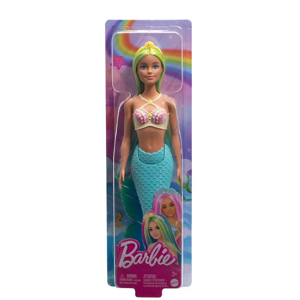 Barbie mermaid doll in original packaging with turquoise mermaid tail, seashell top, and long blue and yellow hair, displayed against a rainbow ocean backdrop.