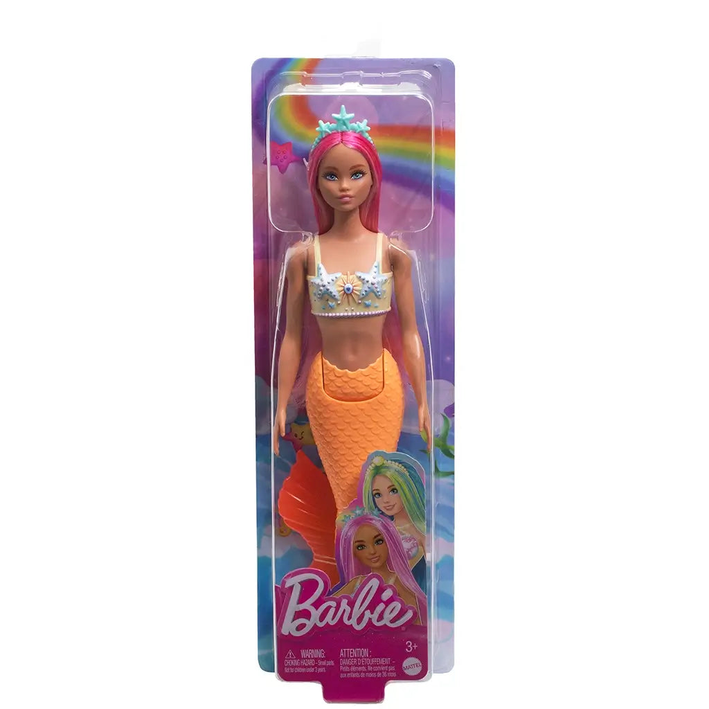 Barbie mermaid doll in packaging, featuring long pink hair, orange tail with scales, starfish top, and blue tiara, set against a colorful rainbow background.