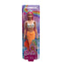 Barbie mermaid doll in packaging, featuring long pink hair, orange tail with scales, starfish top, and blue tiara, set against a colorful rainbow background.