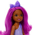 Closeup of Barbie Chelsea doll’s face with deep brown skin, large brown eyes, bright pink lips, long vibrant magenta hair, and a shiny purple bow headband.