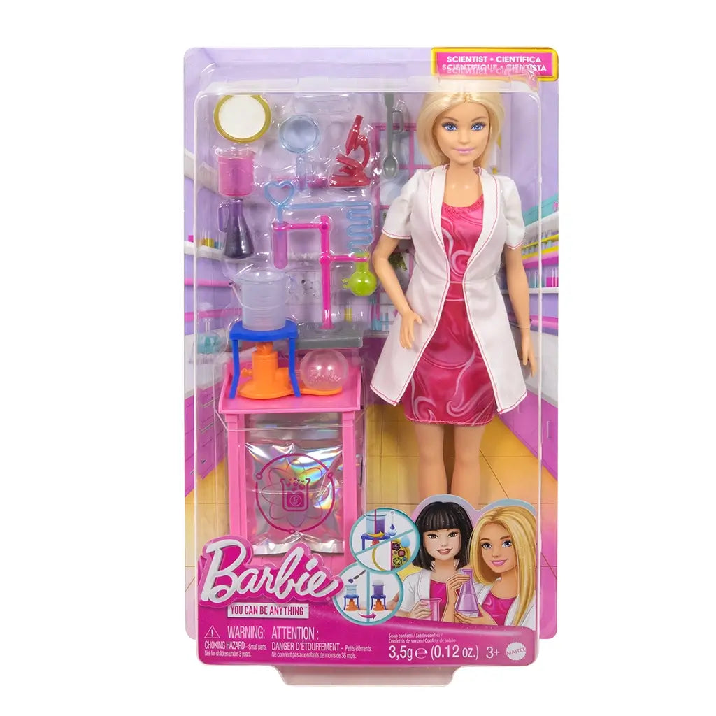 Barbie Scientist Doll in original packaging wearing pink dress and white lab coat, displayed with laboratory accessories including flasks, beaker, test tubes, and science playset pieces.