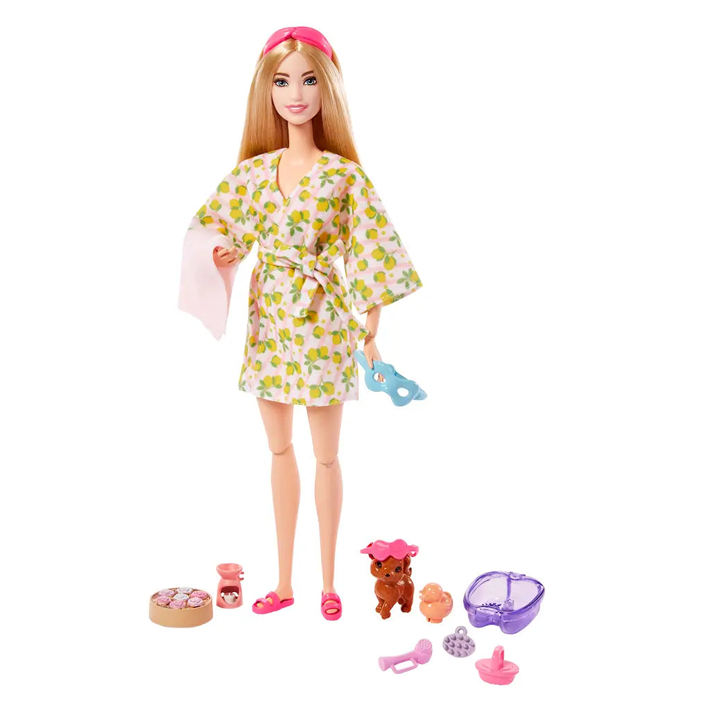 Full Barbie Self-Care Spa Day doll holding a spa mask, wearing a lemon-print robe and pink sandals, posed with included puppy, spa bath, and accessories.