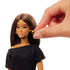 Barbie Signature Basics 2025 Series 1 Model 01 doll close-up with removable gold hoop earring being adjusted by a hand, showing the doll’s long straight brown hair and minimal makeup details.