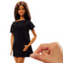 Close-up of Barbie Signature Basics 2025 Series 1 Model 01 doll in a simple black shift dress with short sleeves, accessorized with small gold hoop earrings, shown against a white backdrop.