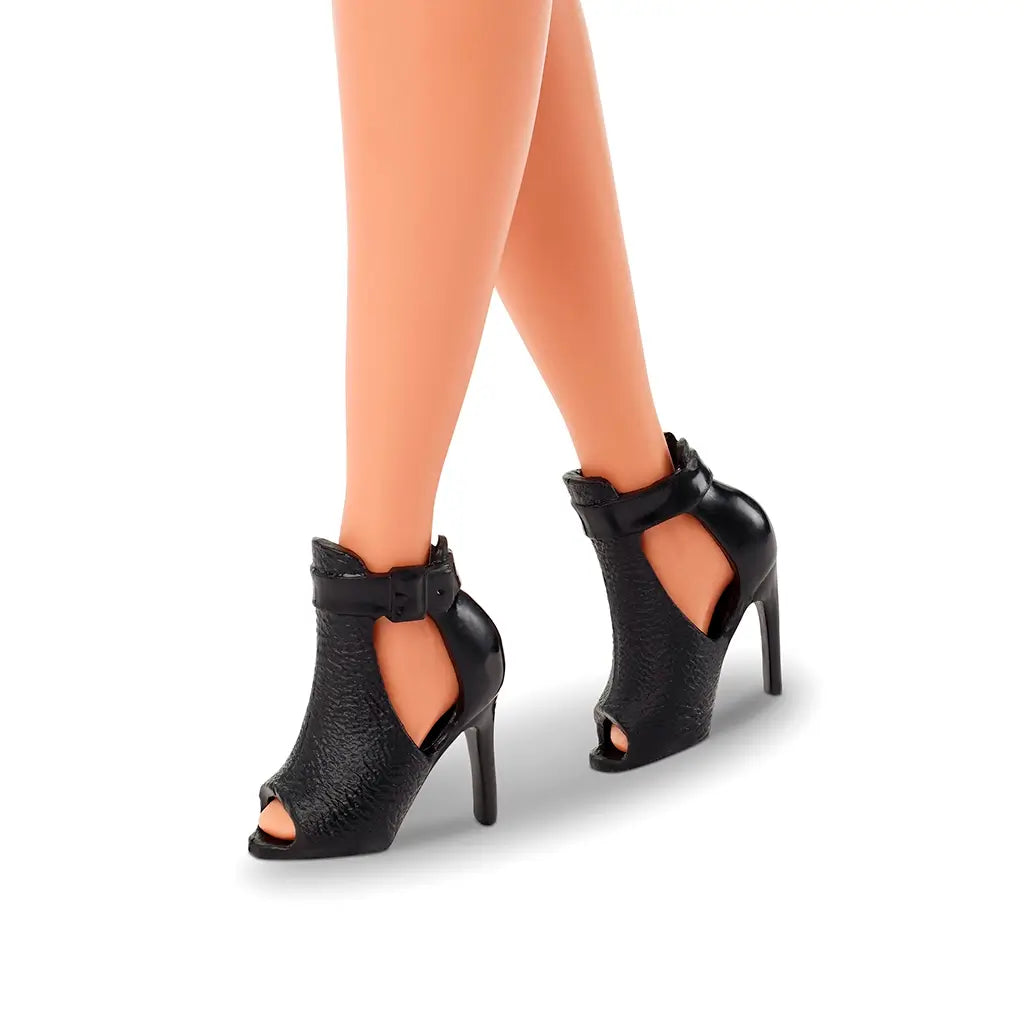 Close-up of black high-heeled peep-toe ankle boots on Barbie Signature Basics Model 05 doll, highlighting detailed textured design.