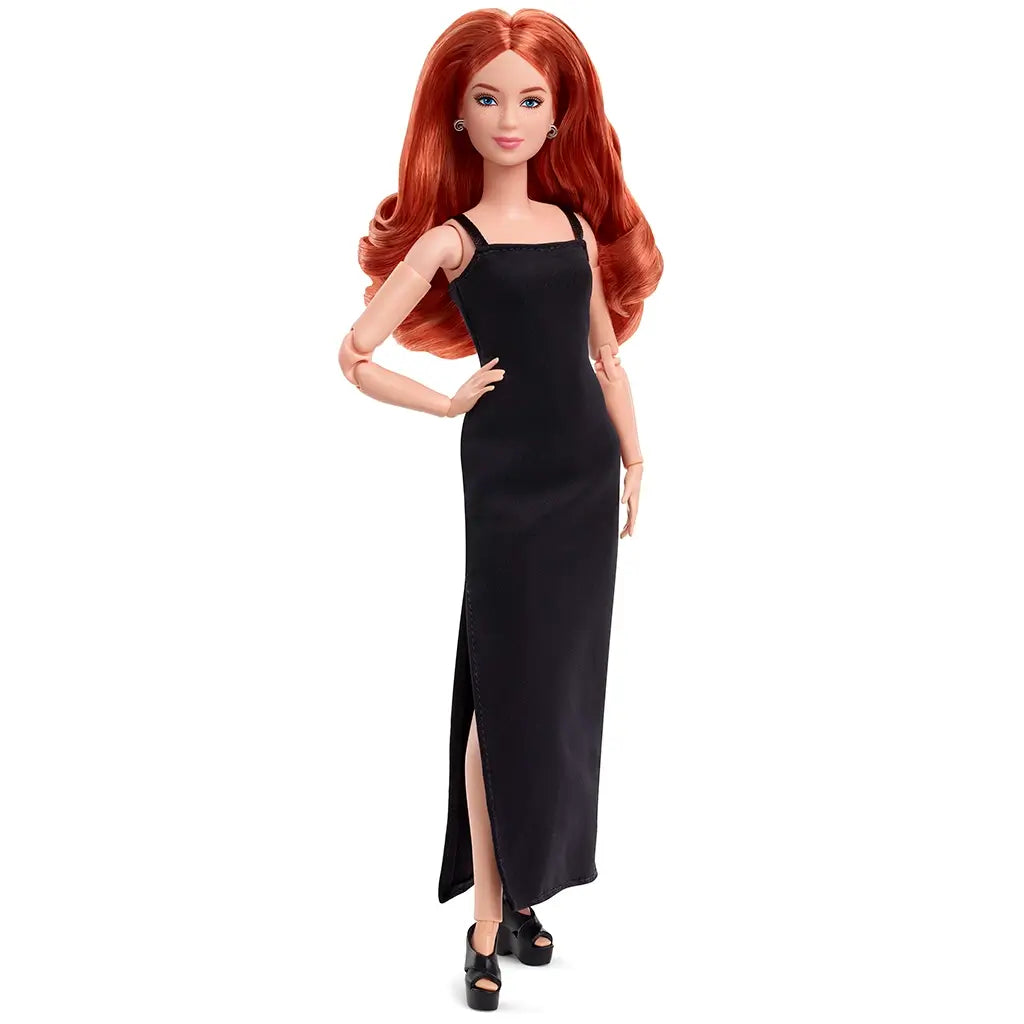 Barbie Signature Basics 2025 Model 4 doll with sleek black slit maxi dress, red wavy hair, and black wedges, standing with one hand on hip against white background.