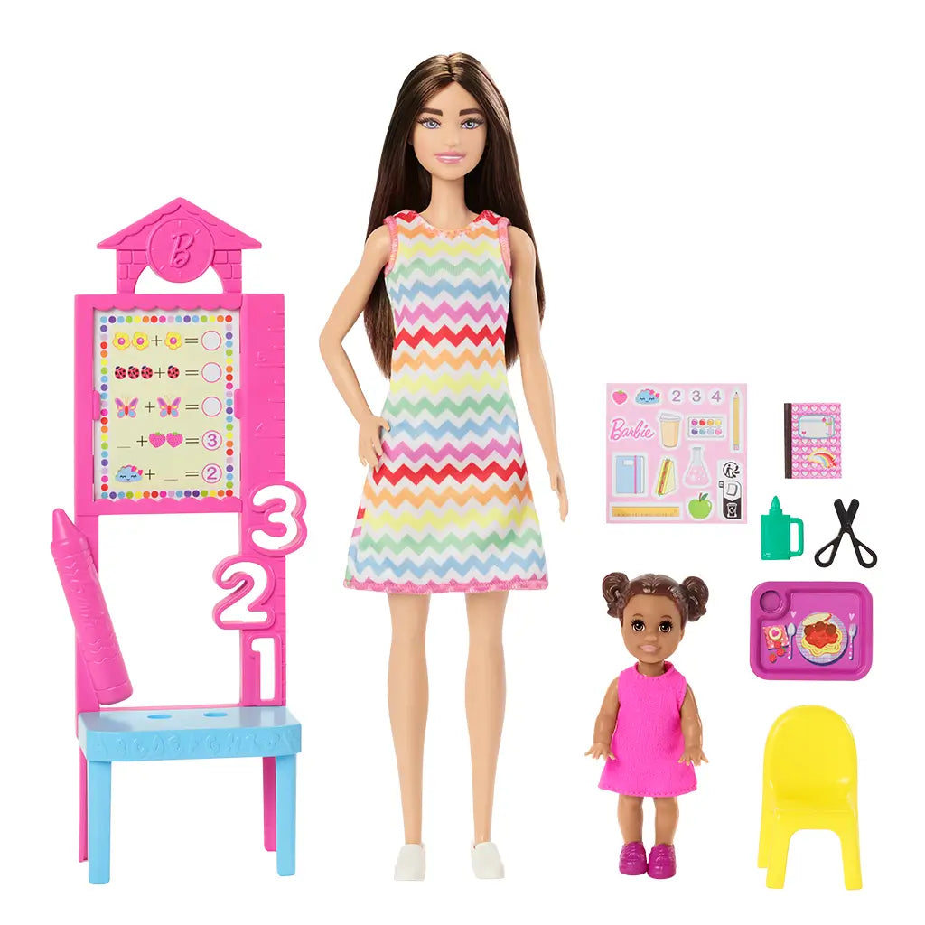 Barbie Teacher fashion doll set with brunette doll in rainbow zigzag dress, student doll in pink dress, chalkboard, yellow chair, and classroom play accessories.