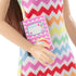 Close-up of Barbie Teacher doll in rainbow zigzag dress holding a pink notebook with heart and rainbow cover design, showing colorful fabric details and accessories.