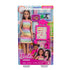Front of Barbie Teacher fashion doll package showing rainbow-dress Barbie, student doll, chalkboard, yellow chair, and classroom accessories inside clear box.