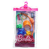 Barbie tourist fashion pack in clear case with orange visor, green camera, red boots, blue star balloon, and playful travel-themed accessories for dolls.