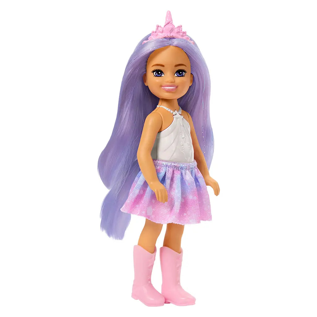 Side view of Barbie Chelsea doll with lavender hair, pink unicorn crown, white top, pastel skirt, and pink boots standing upright.