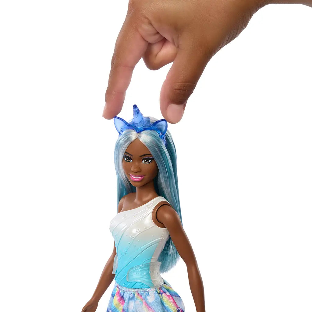 Barbie unicorn doll with long pastel blue hair and blue unicorn headband, shown being touched on the head to demonstrate interactive or styling feature.
