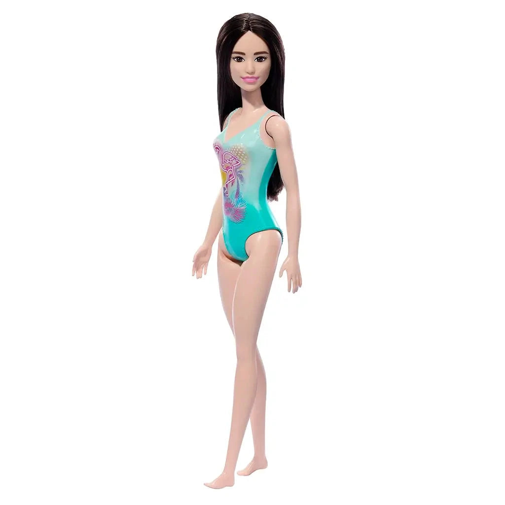 Barbie doll in a teal swimsuit with floral design with a flamingo on a white background