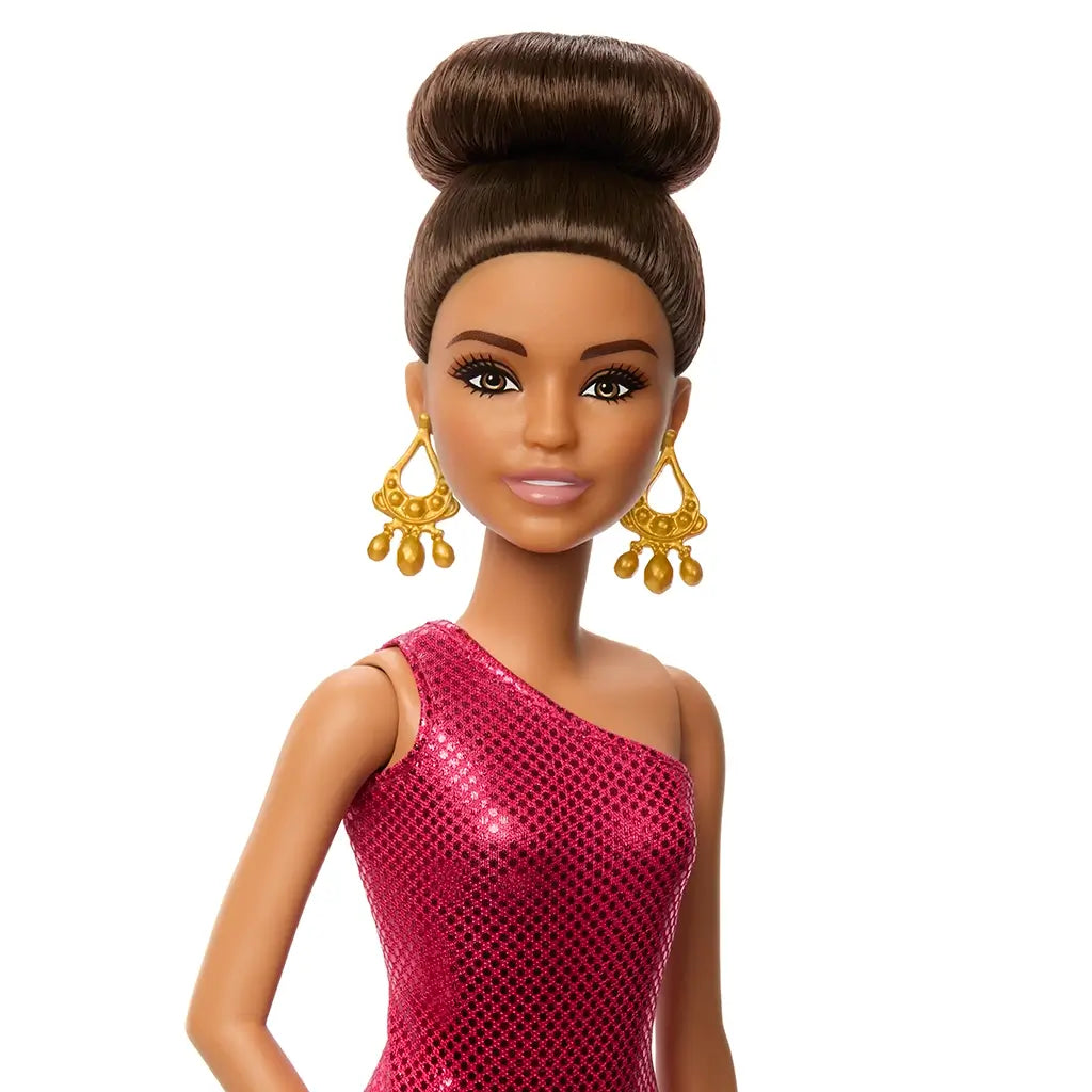 Close-up of Barbie ballroom dancer doll with high bun hairstyle, gold chandelier earrings, and a shimmering fuchsia one-shoulder dress.