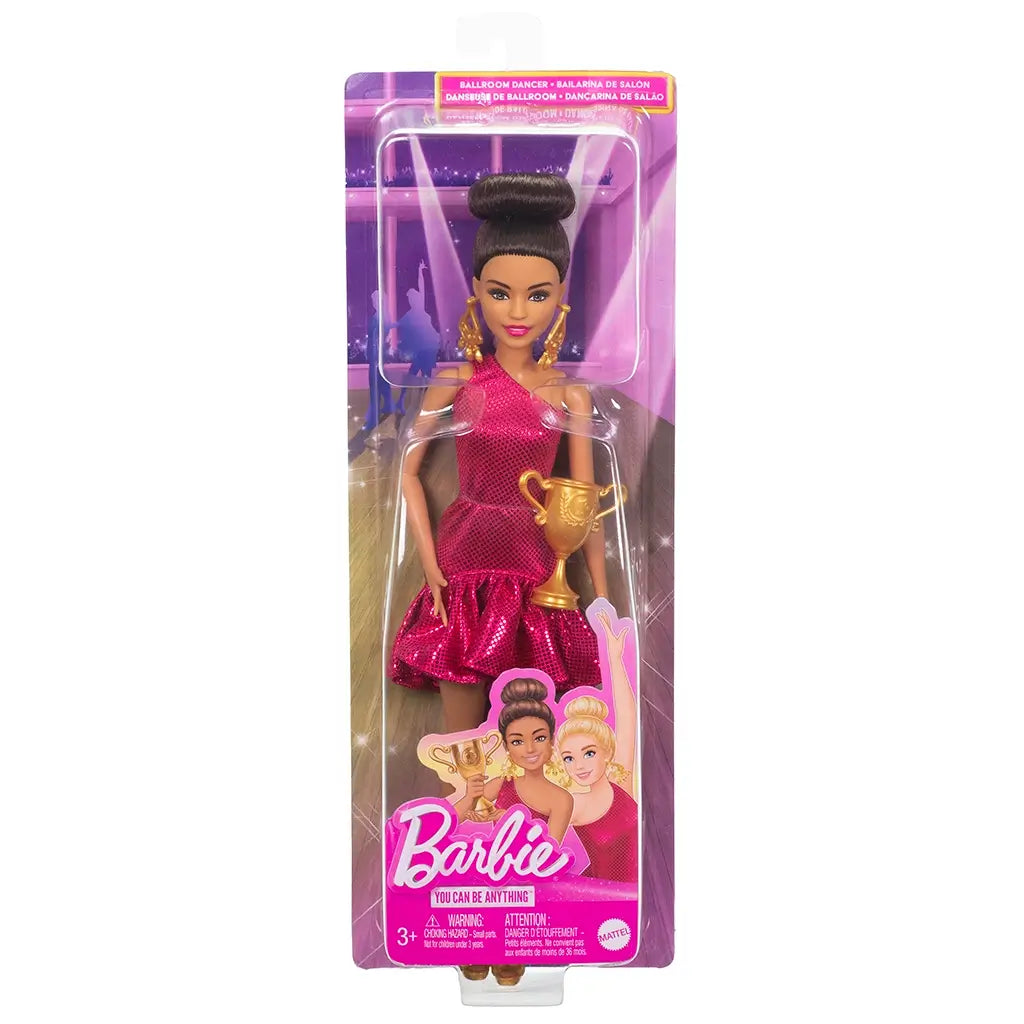Packaged Barbie ballroom dancer doll in glittery fuchsia dress, holding a gold trophy, with illustrated dancers on a purple stage-themed background.