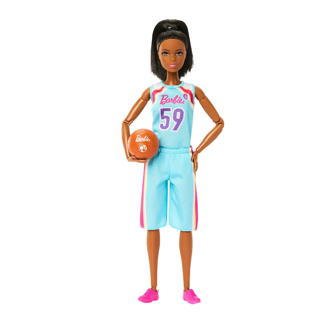 Barbie basketball player doll with black hair in a ponytail, wearing a blue and pink jersey with number 59, posed holding an orange basketball in her left hand.