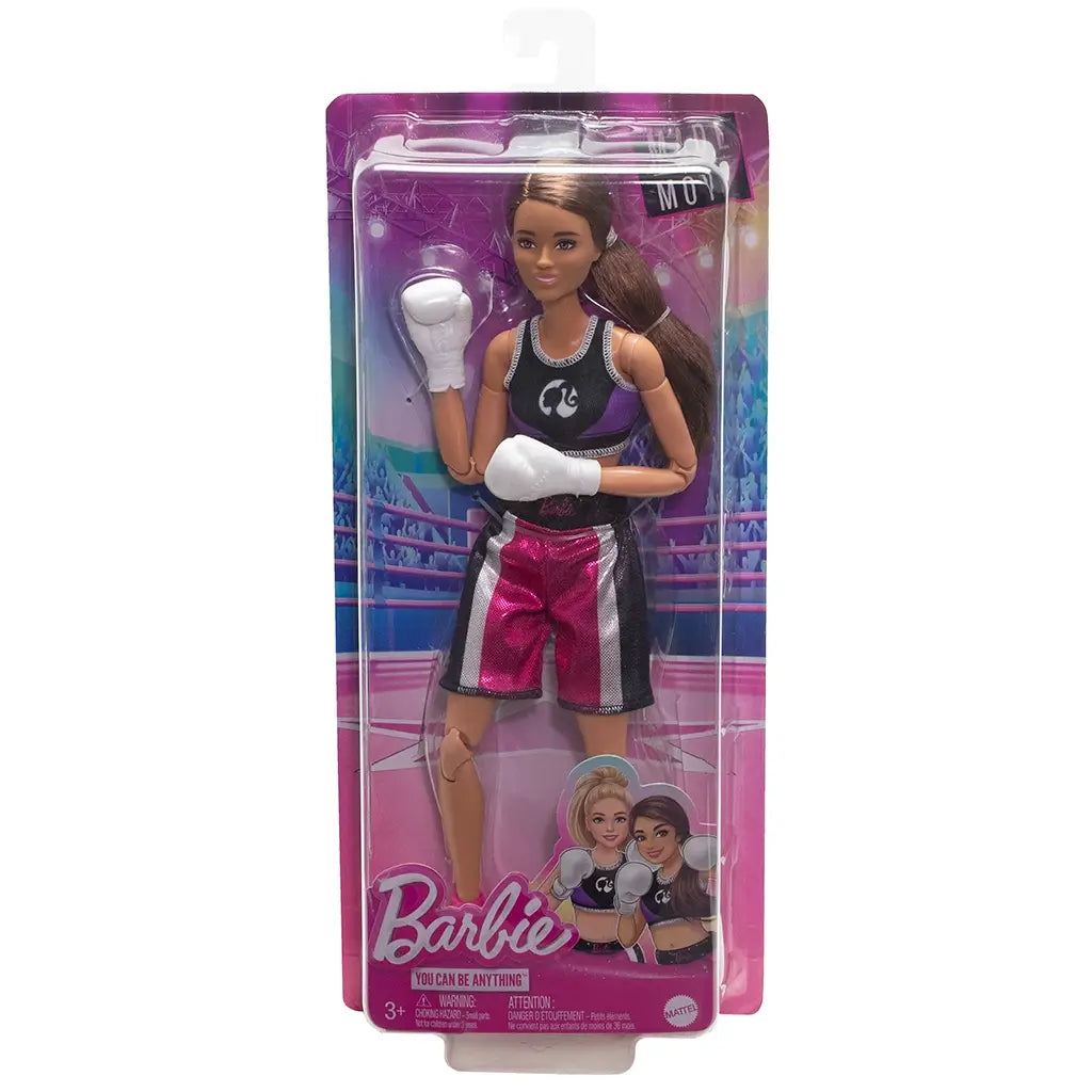 Barbie boxer doll in retail package wearing black crop top, metallic pink boxing shorts, white gloves, and pink boots, posed inside a ring-themed background.