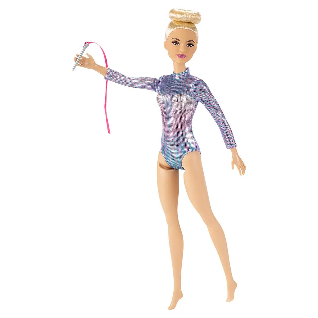 Barbie rhythmic gymnast doll in a shiny purple-blue leotard with long sleeves, blonde hair in a bun, posed holding a silver wand with a flowing pink ribbon.