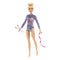Barbie rhythmic gymnast doll with blonde hair in a bun, dressed in a sparkly purple-blue leotard, posed holding silver clubs and a pink ribbon accessory.