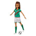 Barbie soccer player doll in green and white uniform posed mid-kick with a detachable black-and-white soccer ball on the ground, featuring long brown hair tied back with headband.