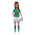 Barbie soccer player doll wearing green jersey with number 16, white shorts, and green knee socks, holding a black-and-white soccer ball, smiling with brown hair in ponytail.