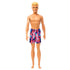 Front view of Beach Ken doll with blond hair, tan skin, and colorful swim trunks, standing barefoot.