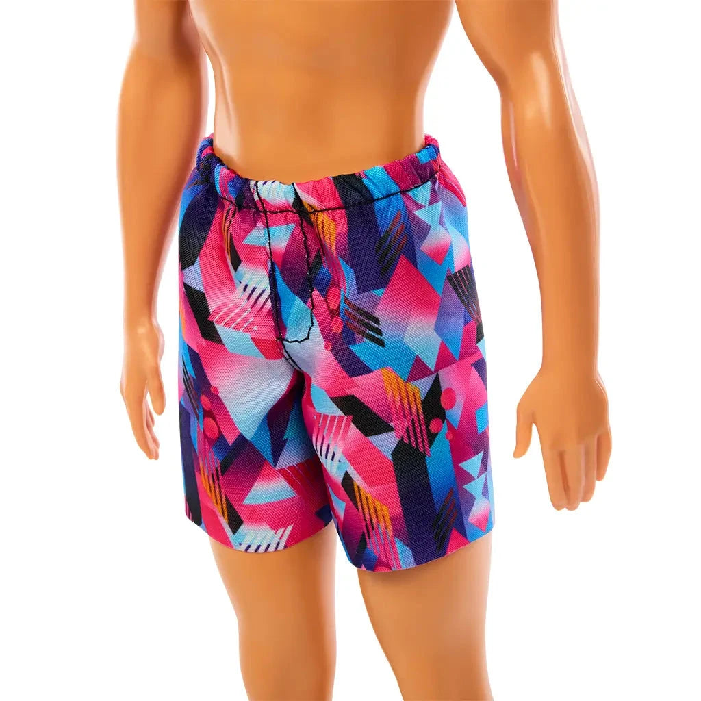 Close-up of Beach Ken doll’s colorful geometric-patterned swim trunks in purple, pink, and blue.
