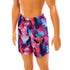 Close-up of Beach Ken doll’s colorful geometric-patterned swim trunks in purple, pink, and blue.