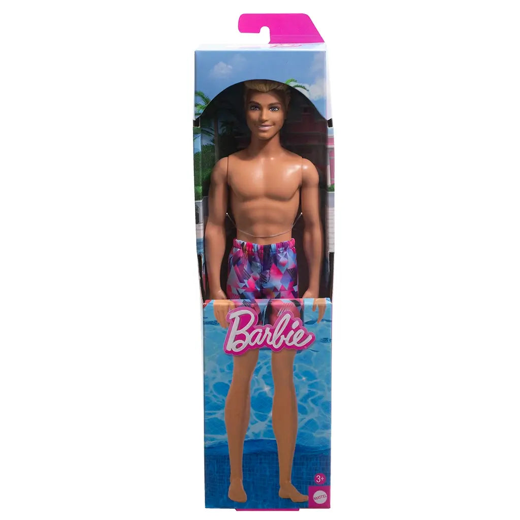 Beach Ken doll with blond hair wearing colorful purple, pink, and blue swim trunks, displayed in packaging with poolside background.