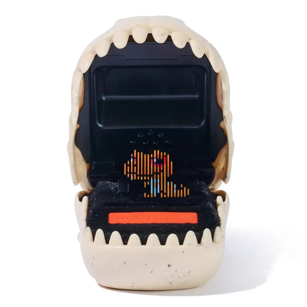 Jurassic World Bitzee digital pet device designed as an open dinosaur jaw in off-white plastic, revealing a black interior screen with animated pixel dinosaur graphics, photographed in a studio white setting.