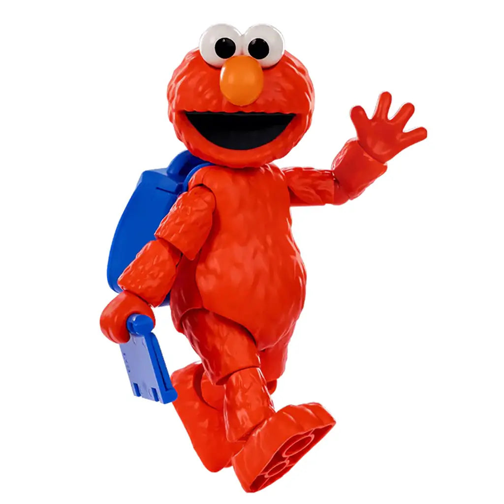 Red plastic Elmo toy figure from Sesame Street waving while walking, holding a blue accessory with matching backpack, showing detailed fur texture and smiling expression.