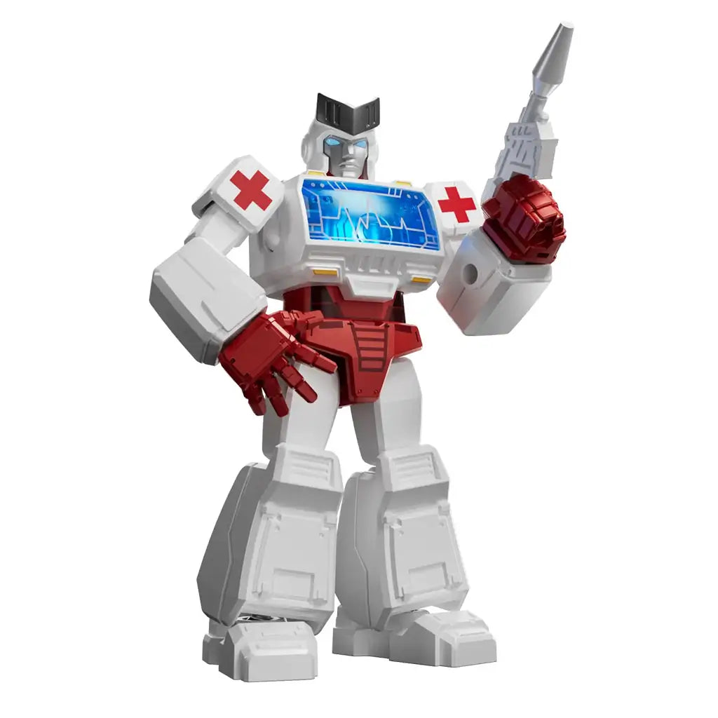 Transformers toy figure of Ratchet featuring white and red robotic armor with a blue chest panel, red cross symbols on shoulders, and a dynamic pose holding a medical blaster weapon.