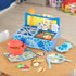 Blue’s Clues-themed toy cooking set on a table with red pot, pretend food, utensils, sink, stove, recipe cards, and colorful play pieces.