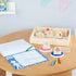 A child’s desk setup featuring the Melissa & Doug Blue’s Clues & You! wooden handle stamps activity set with wooden stamps, ink pads, crayons, and paper for creative art play and fine motor development.