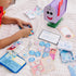A child arranges letters and tokens from the Melissa & Doug Blue’s Clues & You! wooden mailbox play set on a cozy blanket, creating storytelling games that build language and social skills.