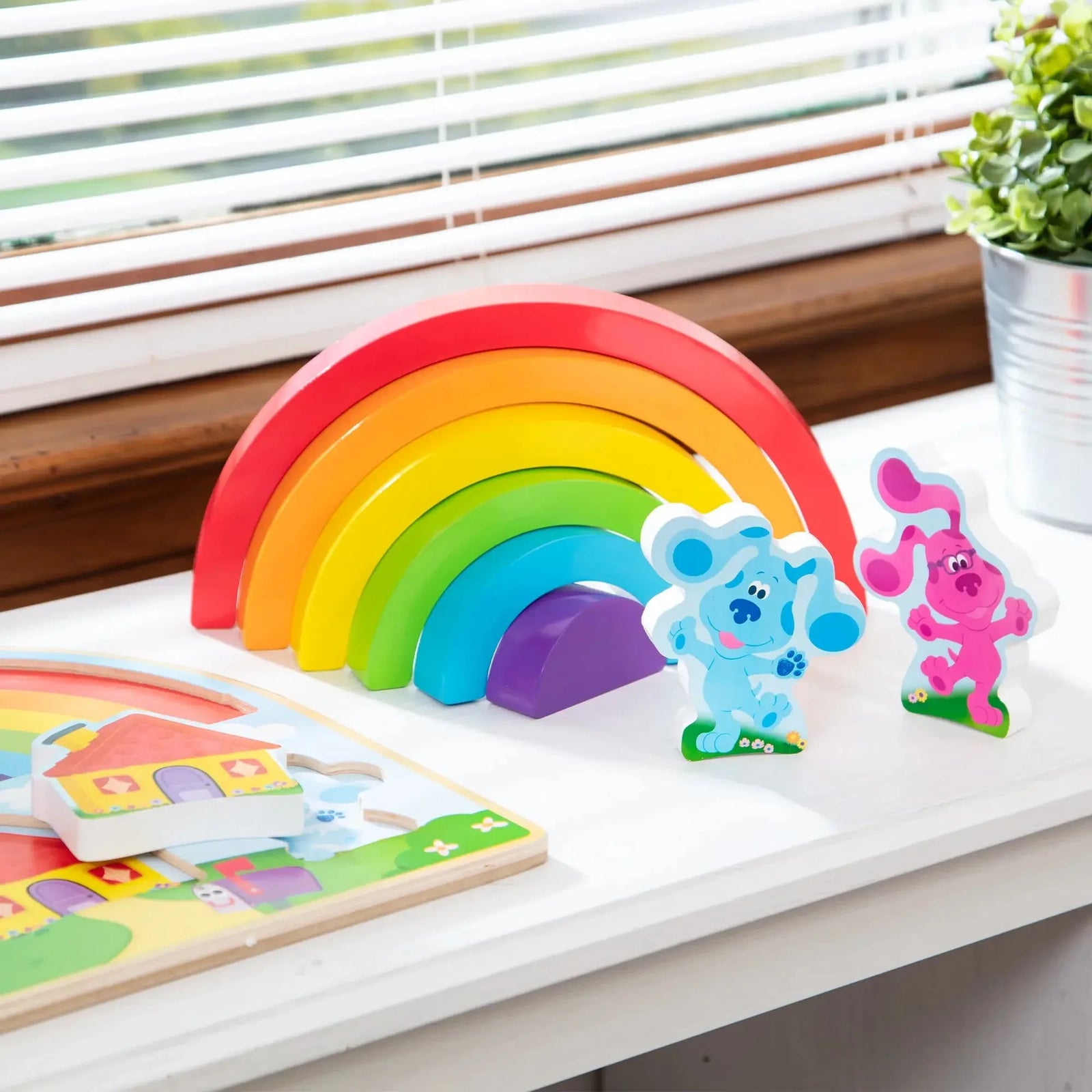 Colorful wooden rainbow arches from Melissa & Doug’s Blue’s Clues puzzle set, with Blue and Magenta characters standing upright for imaginative play.