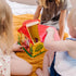 Toddlers playing with Blue’s Clues take-along house toy, lifting the roof and exploring puzzle blocks and shape sorter features during group play.