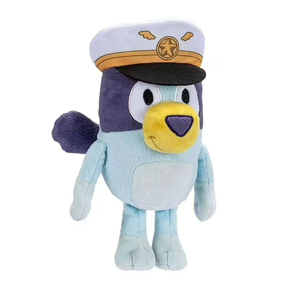 Captain Bluey plush toy made of velvety blue and navy fabric appears in a three-quarter view highlighting its yellow muzzle, stitched belly patch, and white captain’s hat decorated with gold wing details on a clean white backdrop.