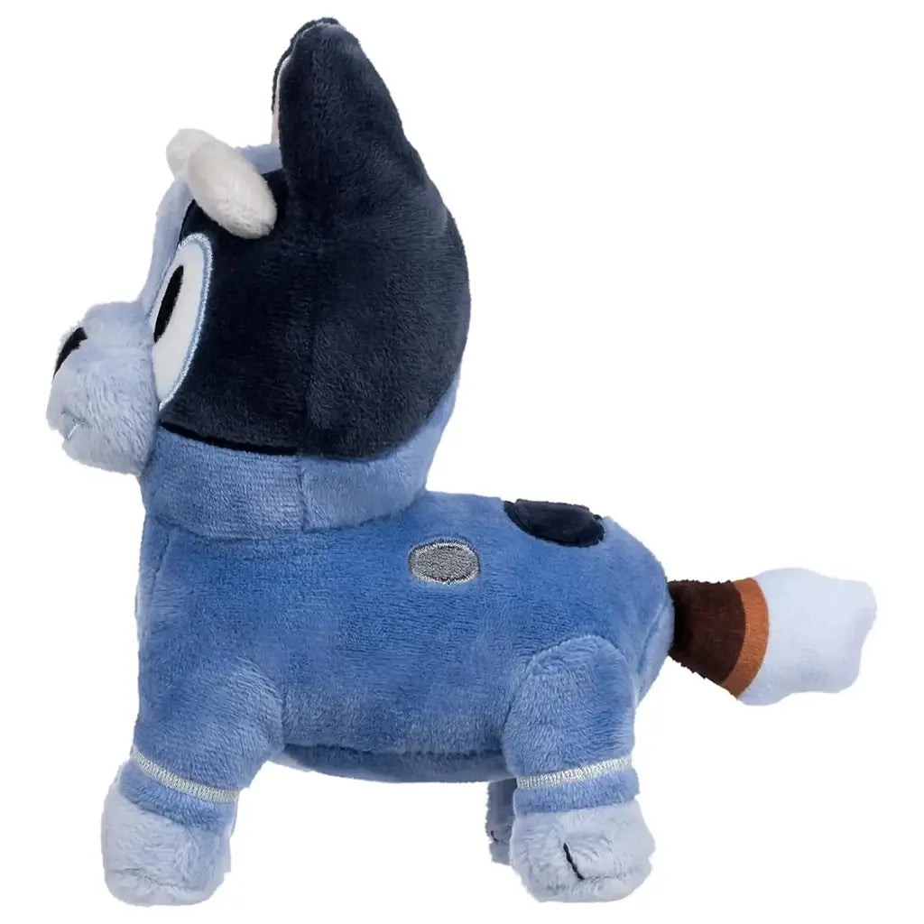 Bluey Socks plush toy in soft blue and navy fabric is shown from the side, revealing stitched spots, upright ears, and a banded tail, with its rounded body posed clearly against a simple white background.
