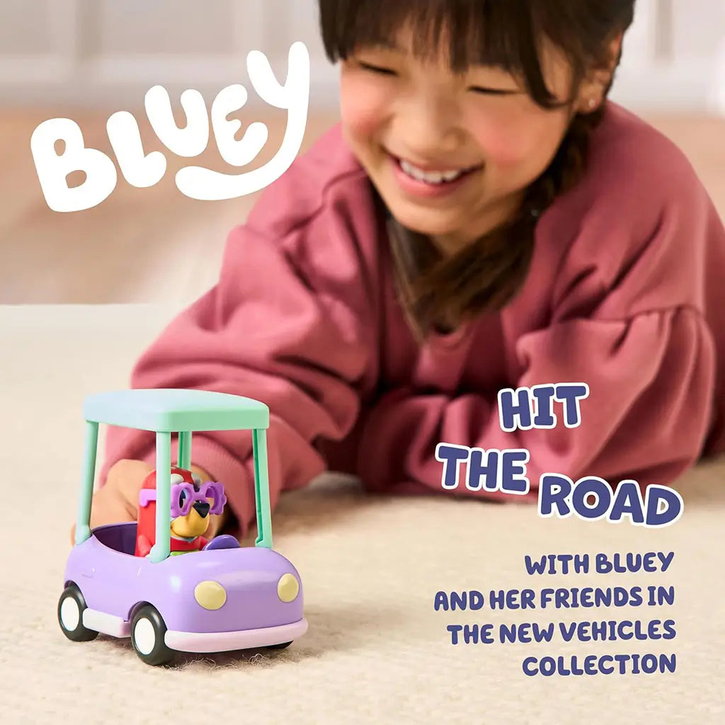 Child smiling while pushing the Bluey Granny Car toy with Janet figure inside, demonstrating scale, easy-rolling wheels, and hands-on imaginative play indoors.