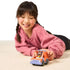 Child smiling while playing with the Bluey Mini 4WD vehicle and Bluey figure on the floor, demonstrating imaginative play.